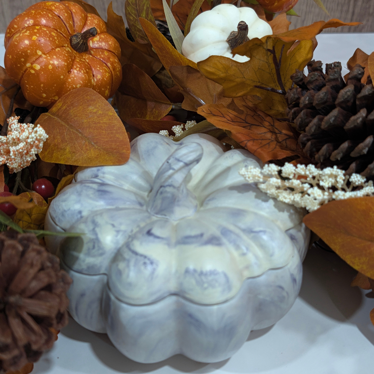 Handcrafted large pumpkin with blue purple swirls lines in front of Autumn decoration