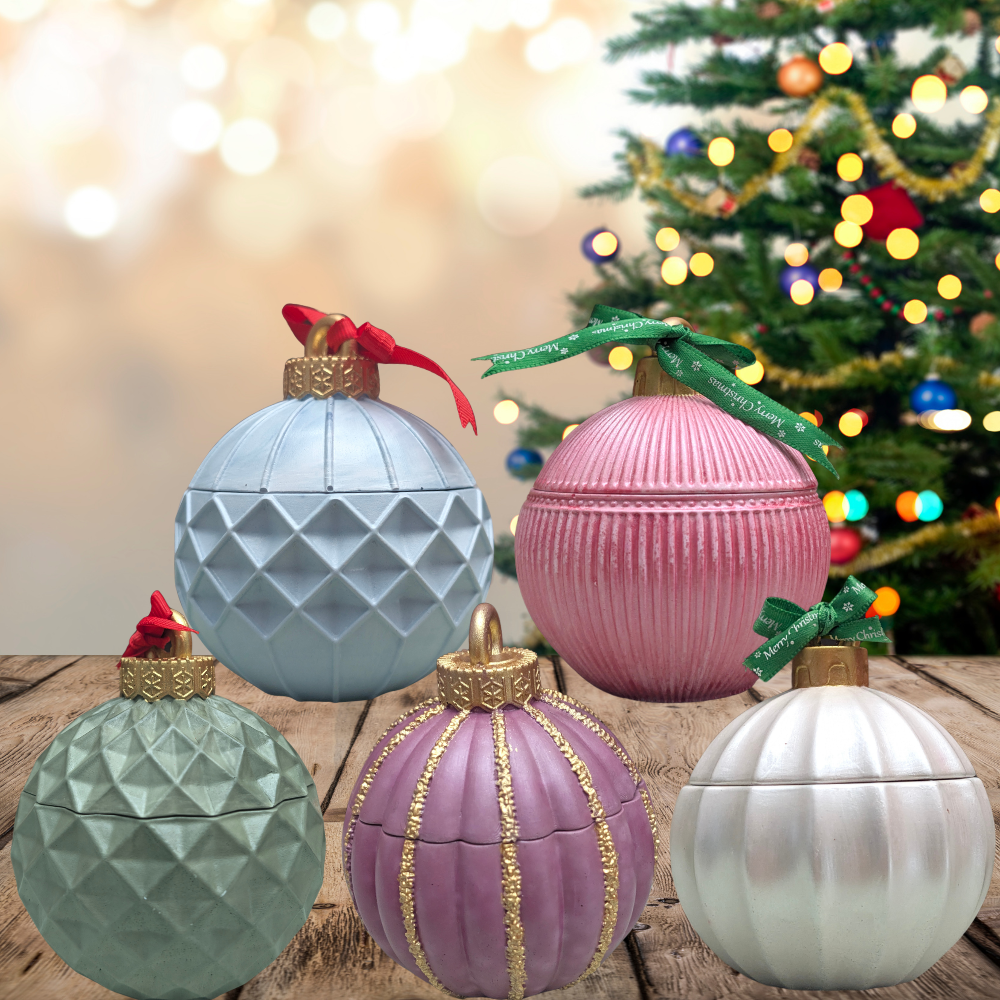 We have five different concrete ornaments vessels the colors are light blue, pink, green, burgundy, white in top of a wood countertop and in the back have a Christmas tree as a background