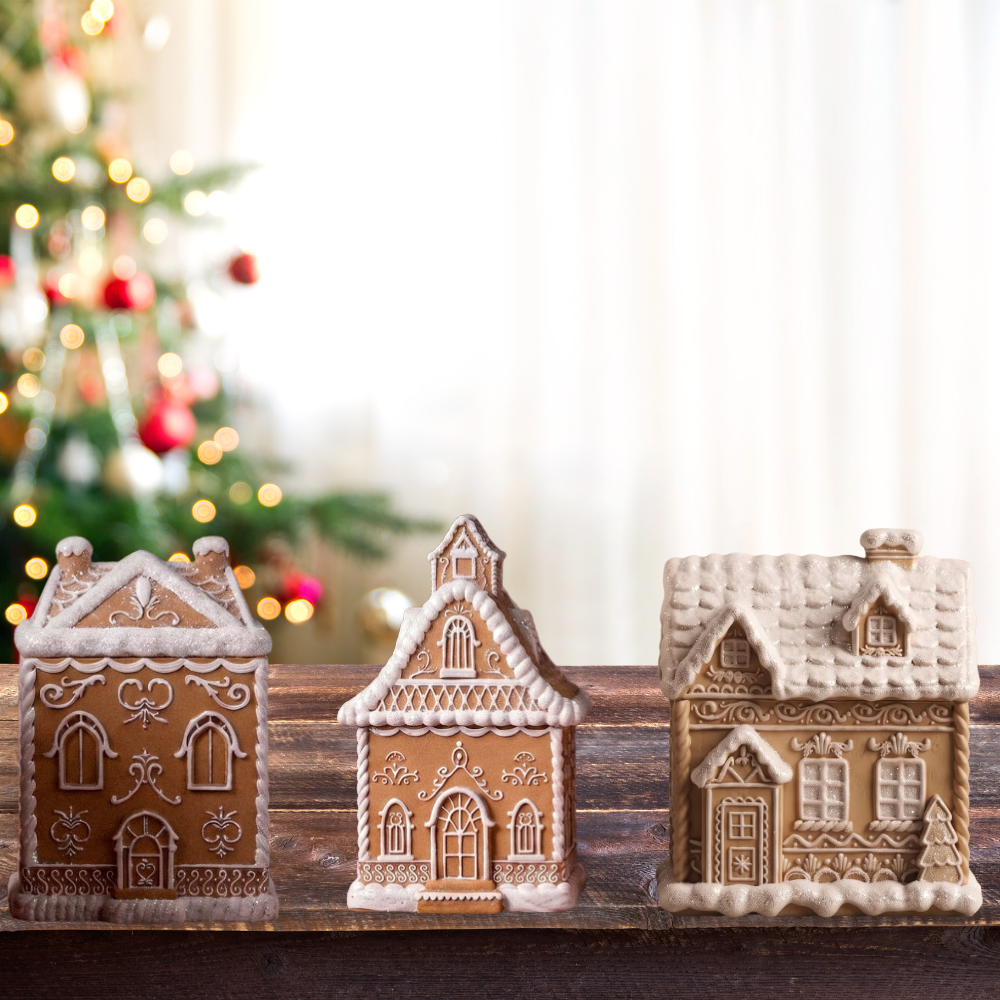We have 3 gingerbread vessels houses the color is brown and white. The white is simulating snow in top of wood countertop in front of a Christmas tree as a background